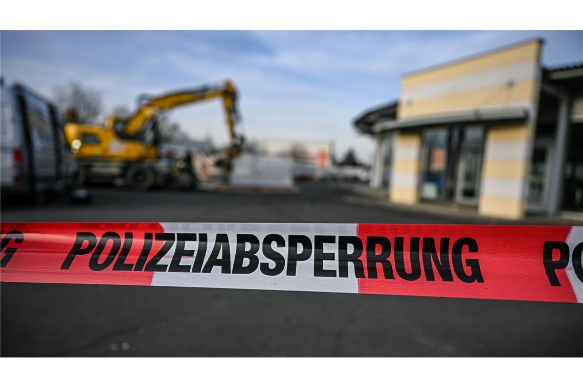Baggerfahrt: Ermittler gehen von persönlichem Motiv aus Ein Bagger steht nach einer Zerstörungsfahrt neben einem Autohaus in Tauberbischofsheim hinter einer Polizeiabsperrung. War das Motiv für die Tat ein persönliches? (Archivfoto)