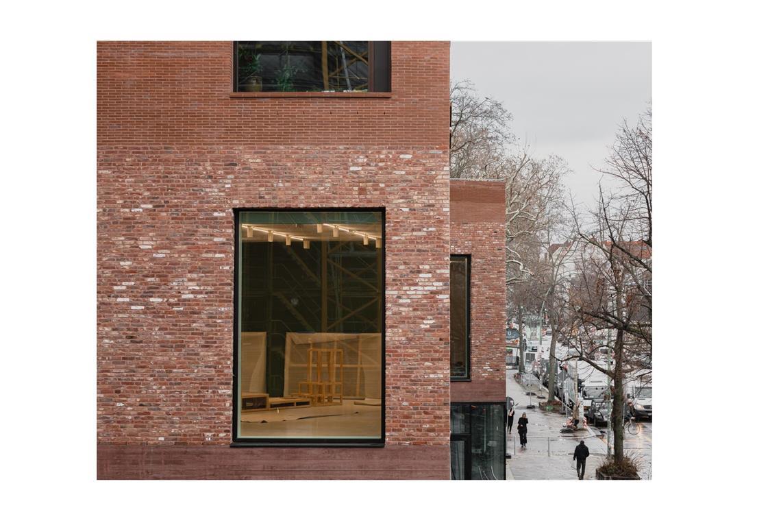 Deutschlands bestes Haus steht in Berlin-Neukölln Ein Band aus recycelten Ziegeln kennzeichnet das Ausstellungsgeschoss. Die Fassade ist dreifach geschichtet: rot eingefärbter Beton im Erdgeschoss, recycelte Ziegel im ersten Obergeschoss, darüber neue Ziegel.