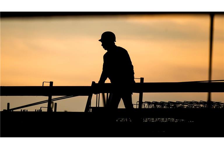 Ein Bauarbeiter in der Morgendämmerung. Laut Ifo-Beschäftigungsbarometer wollen viele Unternehmen Personal abbauen, in der Baubranche zeichnet sich jedoch keine größere Entlassungswelle ab.