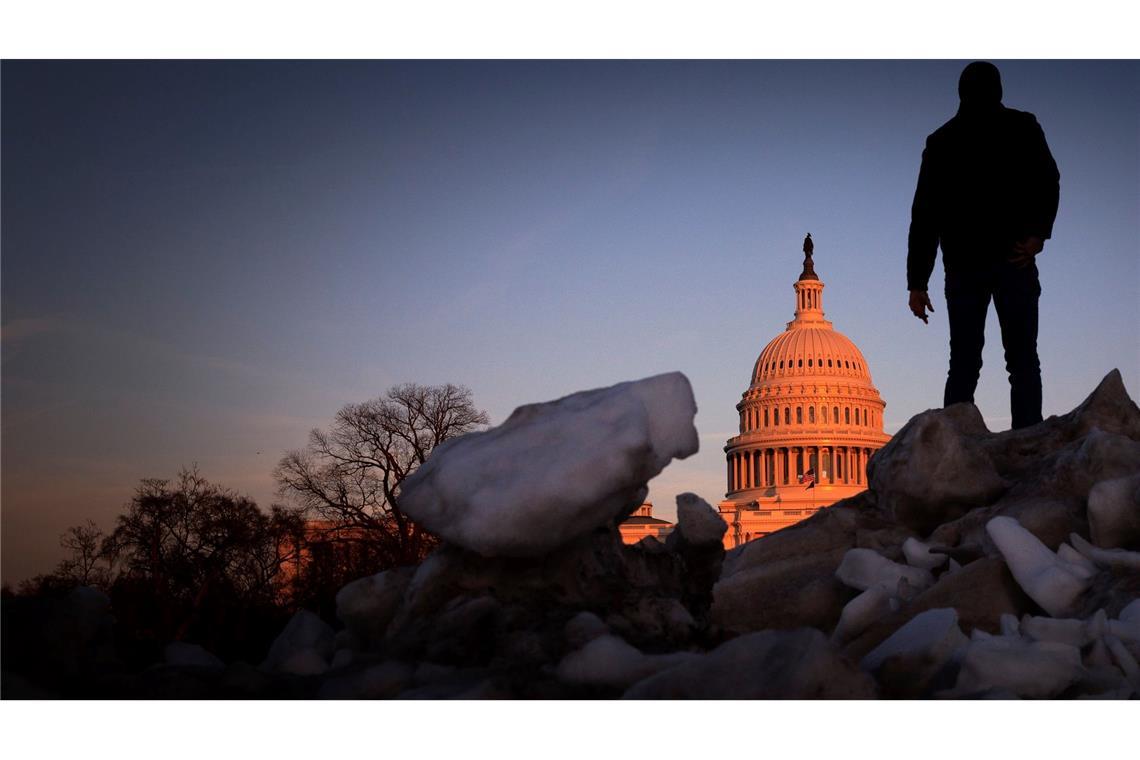 Ein Besucher aus Tschechien klettert bei Sonnenuntergang auf einen Schneehaufen auf dem Capitol Hill in Washington.