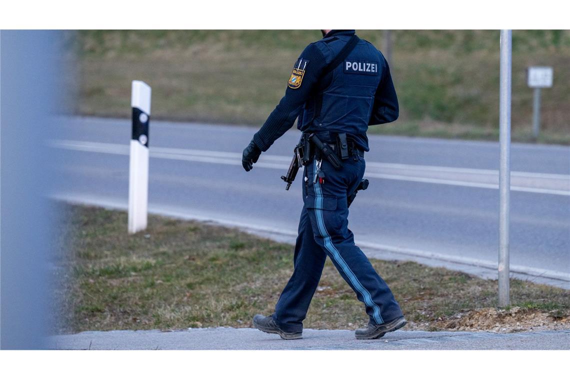 Todesschüsse auf Hochzeitsfeier - Verdächtiger stellt sich Ein bewaffneter Polizist geht auf einer Straße am Ortsrand von Parsberg.