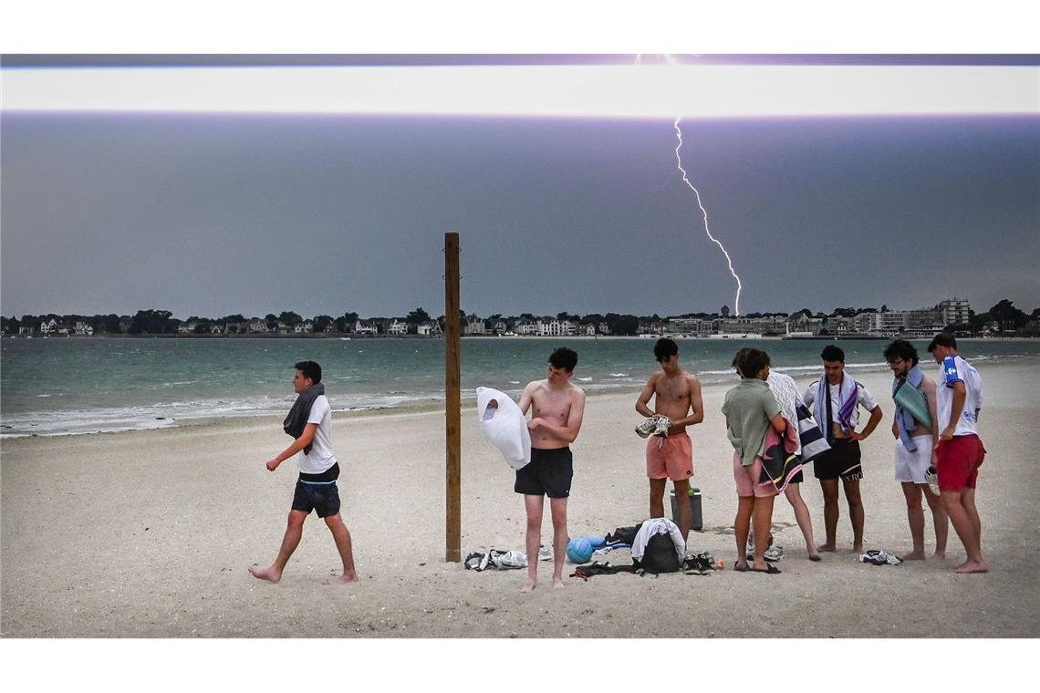 Bilder des Tages Ein Blitz erhellt den Himmel, während Menschen den Strand während eines Gewitters über der Stadt La Baule im Westen Frankreichs verlassen.