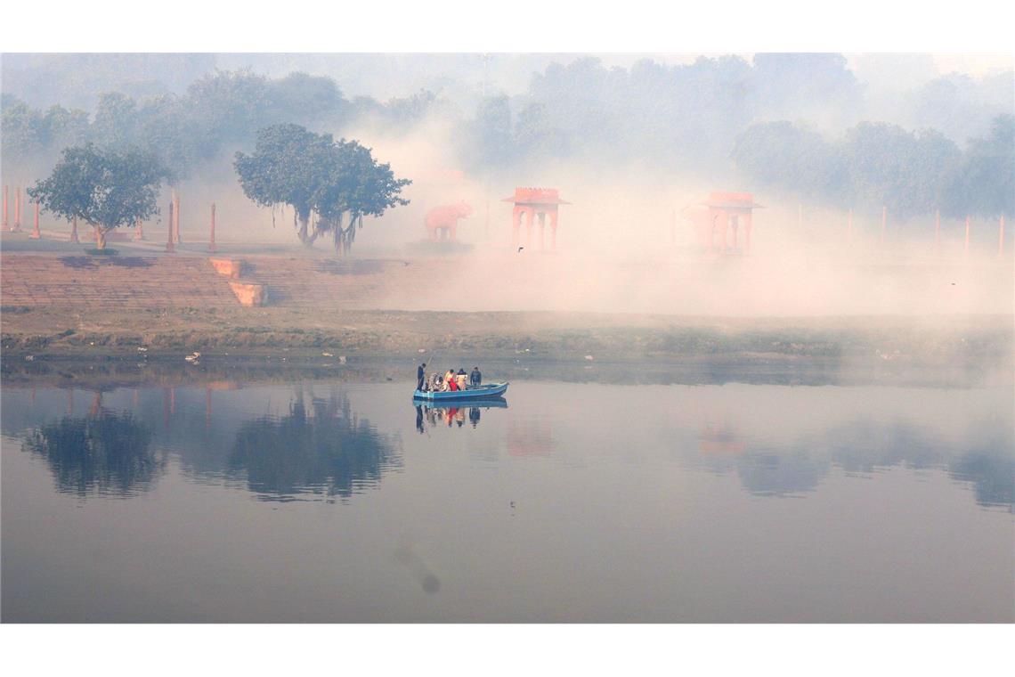 Ein Boot fährt bei Nebel auf dem Yamuna-Fluss.