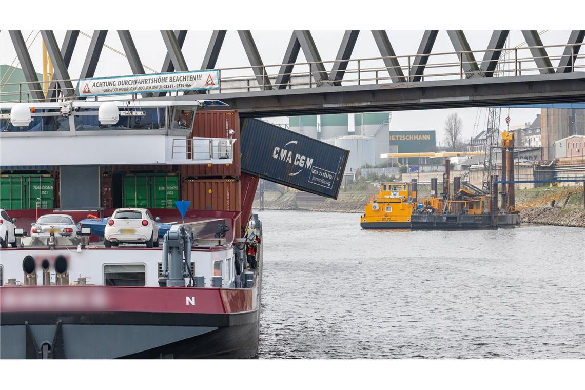 Ein Containerschiff liegt im Neusser Hafen. Das Schiff hat eine Brücke gerammt, mehrere Container fielen ins Wasser.