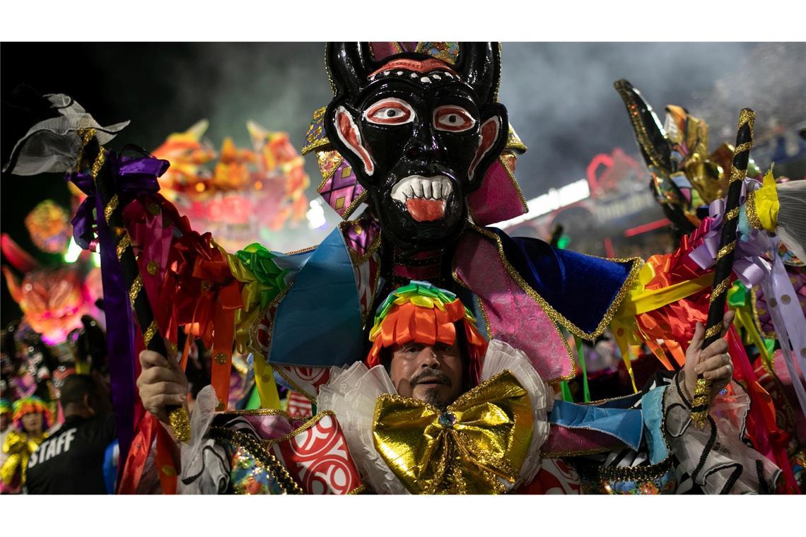 Ein Darsteller der Sambaschule Beija Flor zieht während der Karnevalsfeierlichkeiten im Sambadrom durch die Straßen.