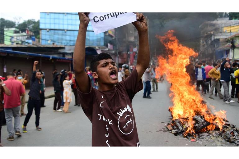Ein Demonstrant in Nepal hält ein Blatt mit der Forderung nach einem Ende der Korruption hoch.