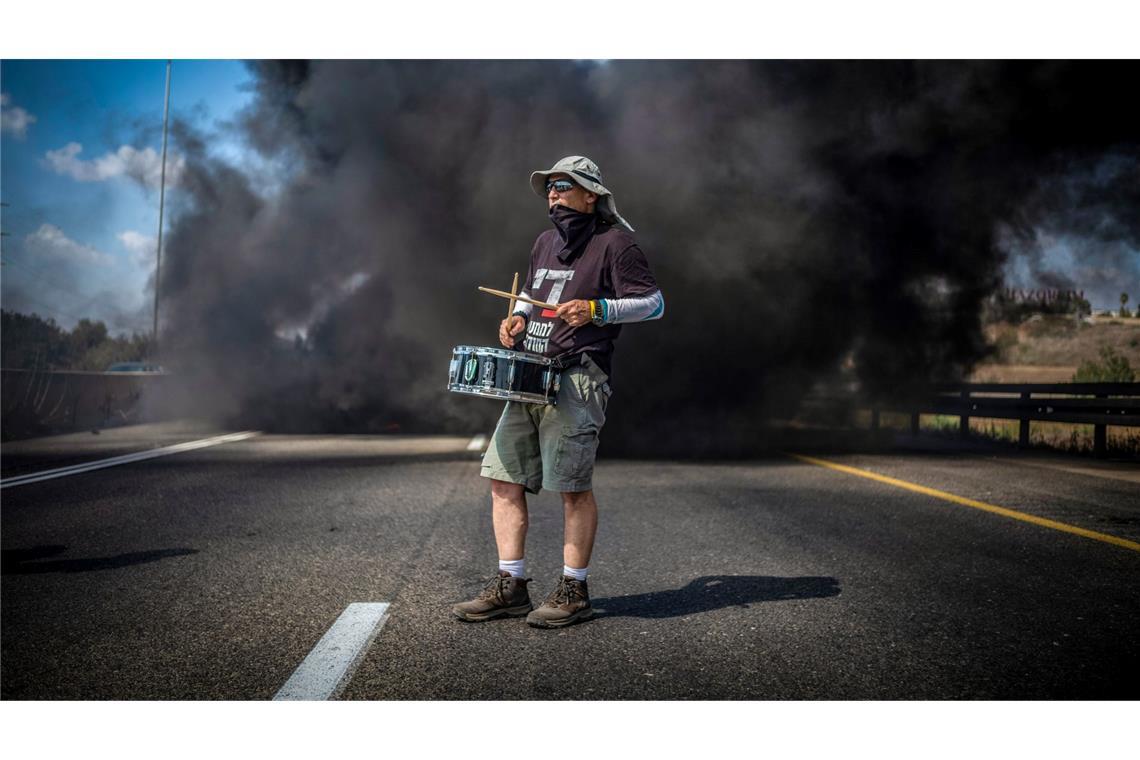 Bilder des Tages Ein Demonstrant trommelt bei einer Straßenblockade in Israel für die sofortige Freilassung aller von der Terrororganisation Hamas festgehaltenen Geiseln und das Ende des Krieges im Gazastreifen.