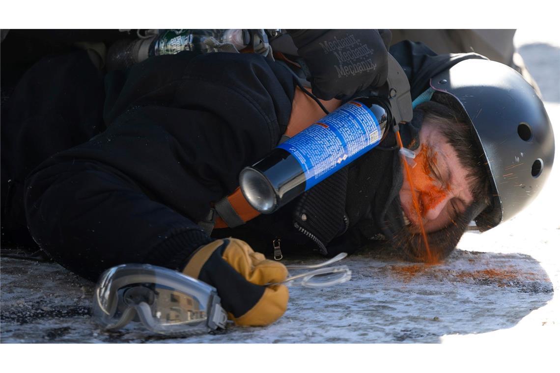 Ein Demonstrant wird aus nächster Nähe mit Pfefferspray besprüht.