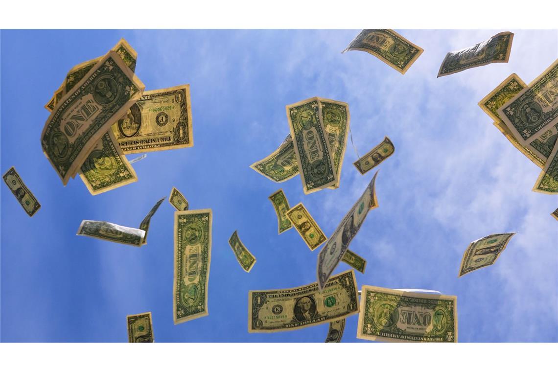 Ein-Dollar-Scheine aus den USA fallen mit dem Himmel im Hintegrund in Dallas.