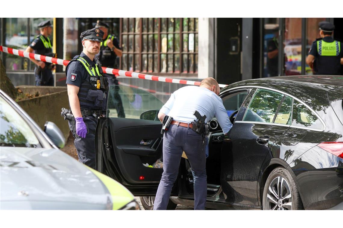 Bilder des Tages Ein Ermittler durchsucht ein abgestelltes Fahrzeug vor einer Shisha-Bar in Hamburg, in der am Morgen eine tote Person gefunden wurde.