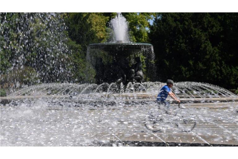 Ein Fahrradfahrer fährt in Dresden zwischen den Wasserfontänen der Brunnen "Stilles Wasser" und "Stürmische Wogen" .