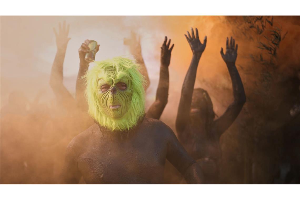 Ein Feiernder mit einer Grinch-Maske posiert während der Mud Block Karnevalsparty in Brasilien.