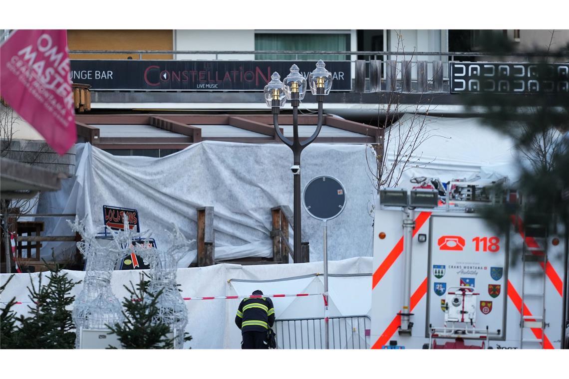 Ein Feuerwehrmann beobachtet die abgeriegelte Bar Le Constellation, in der ein verheerendes Feuer während der Silvesterfeierlichkeiten Tote und Verletzte forderte.