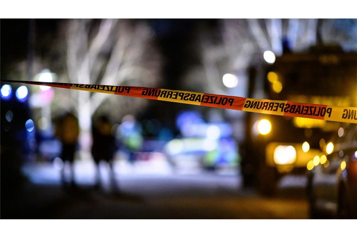 Polizist erschießt vermutlich psychisch kranken Mann Ein Flatterband der Polizei ist vor Einsatzfahrzeugen am Tatort zu sehen.
