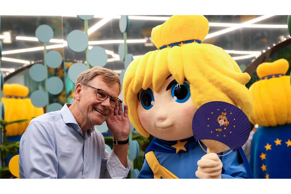 Bilder des Tages Ein Flirt auf der Expo: Außenminister Wadephul und Maskottchen "Europe-Chan" kommen sich im japanischen Osaka im Europa Pavillon näher.