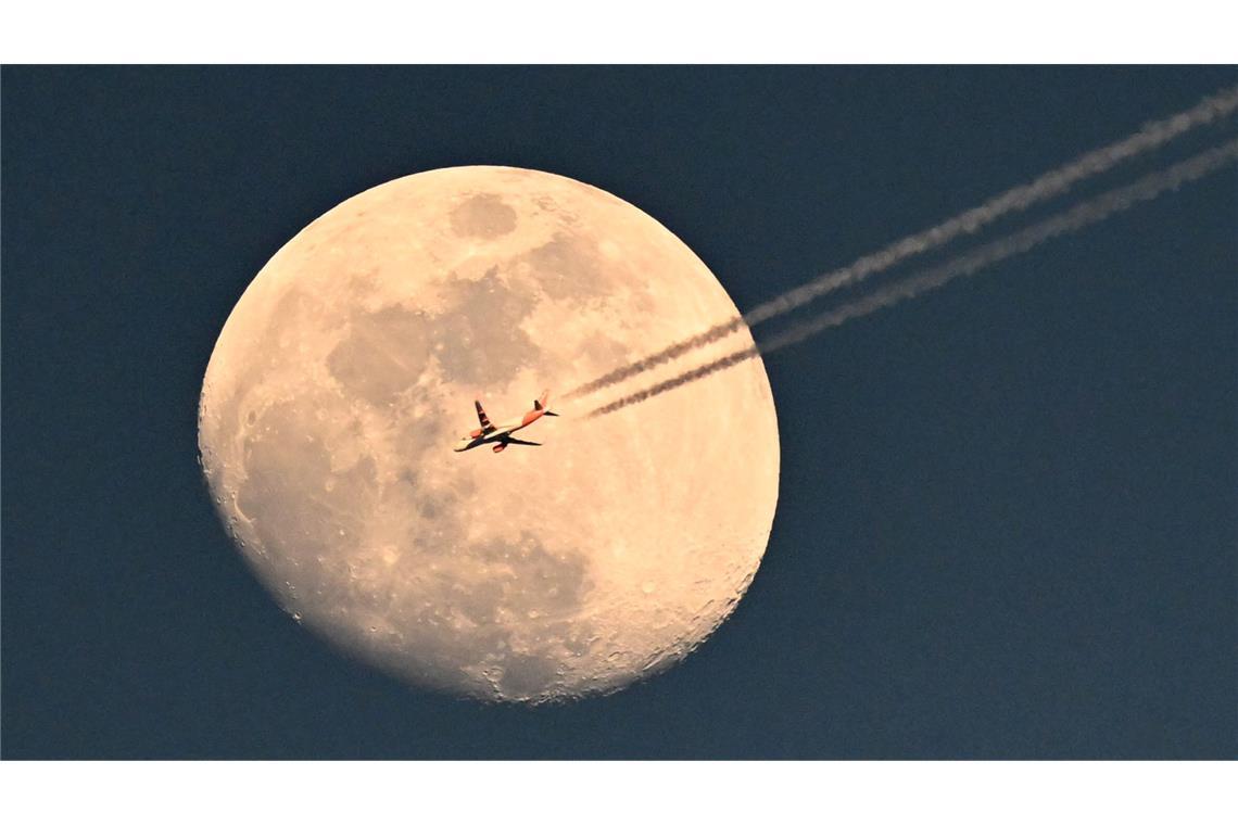 Ein Flugzeug fliegt vor dem zunehmenden Mond über dem Stadion beim Spiel des FC Barcelona gegen Borussia Dortmund.