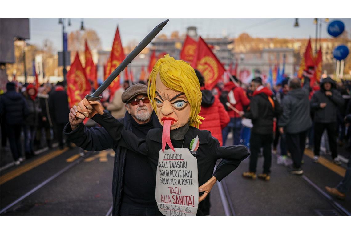 Streik gegen Meloni: Gewerkschaften machen mobil Ein Gewerkschafter hält eine Puppe mit dem Konterfei von Ministerpräsidentin Giorgia Meloni in die Höhe.