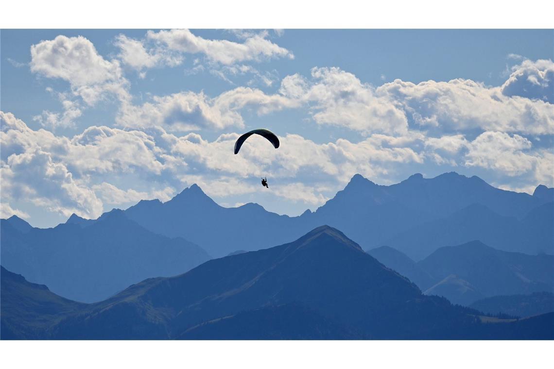 Ein Gleitschirmflieger dreht seine Runden über den bayerischen Voralpen im Tegernseer Tal.
