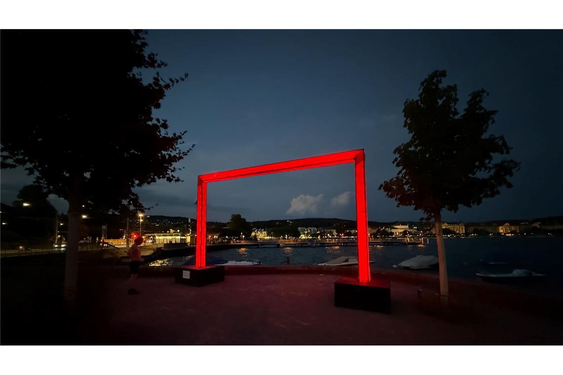 Ein großes rotes Tor, das Teil des Lichtkunstprojekts "Red Goals" zur EM ist, steht am Ufer des Zürichsees.