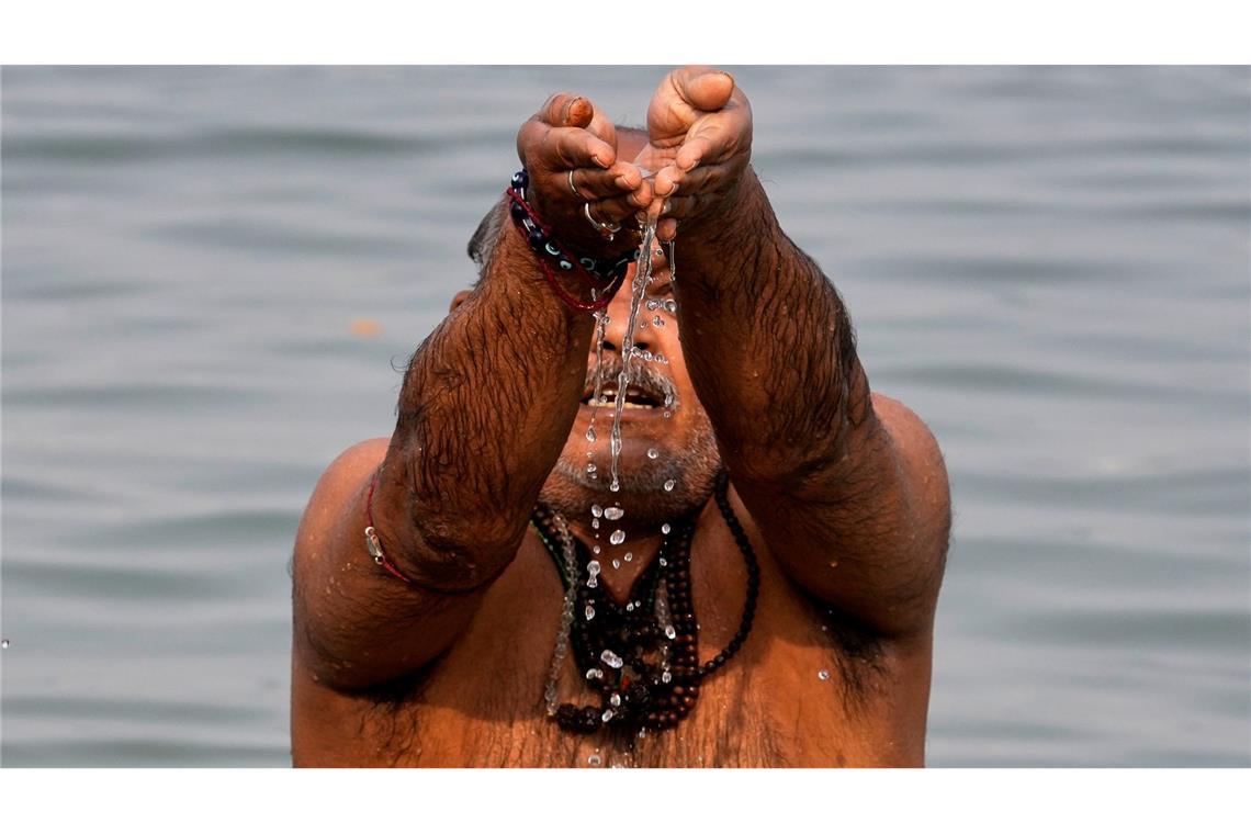 Ein Hindu-Pilger verehrt den Sonnengott während eines rituellen Bades im Hooghly-Fluss anlässlich des Makar Sankranti-Festes in Kolkata.