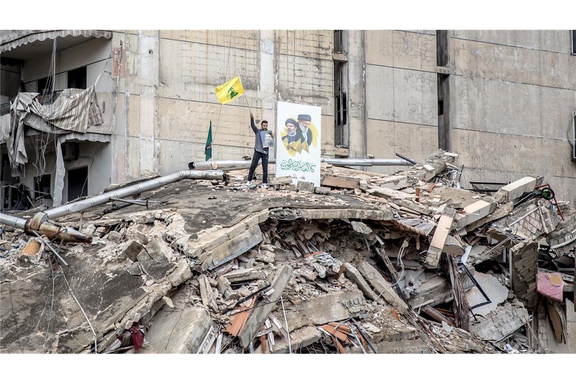 Bilder des Tages Ein Hisbollah-Anhänger schwenkt eine Flagge in Dahieh im Großraum Beirut nach Beginn der Waffenruhe.