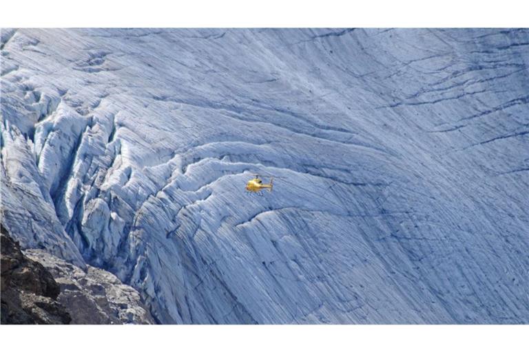 Ein Hubschrauber fliegt über einen Gletscher in der Bernina-Gruppe in den Ostalpen.