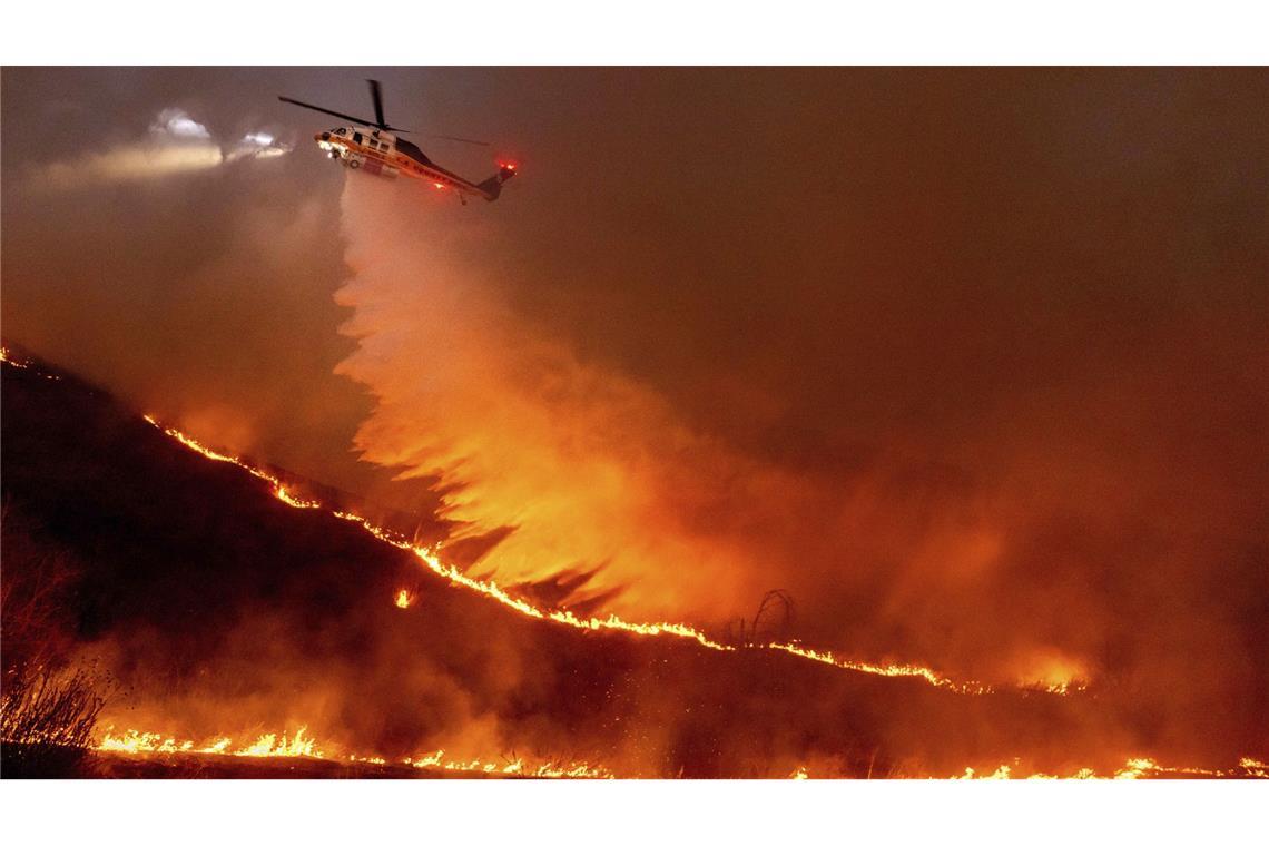 „Wie eine Atombombe“ – Flammeninferno zerstört 10.000 Gebäude Ein Hubschrauber wirft Wasser auf das Kenneth-Feuer in den West Hills von Los Angeles.