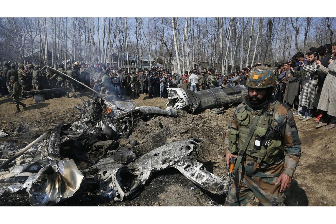 Nach Anschlag in Kaschmir: Pakistan rechnet mit indischem Angriff Ein indischer Soldat geht an den Trümmern eines indischen Hubschraubers im Bezirk Budgam, einem Vorort von Srinagar, im indischen Teil Kaschmirs vorbei.