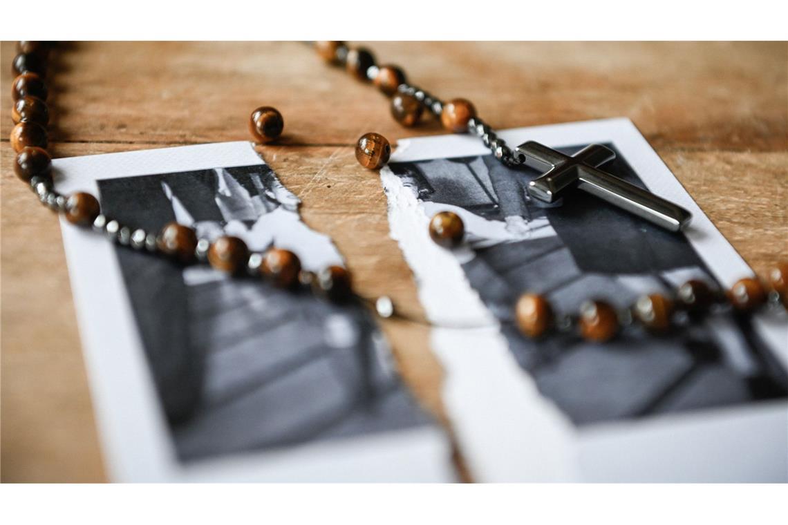 Bistum Würzburg kündigt Konsequenzen an Ein kaputter Rosenkranz liegt auf einem zerrissenen Bild von einem kleinen Mädchen auf einem Tisch, am 27. Januar 2022. Das Bistum äußert sich zum Missbrauchsgutachten.