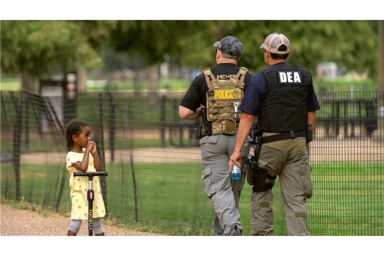 Ein Kind beobachtet, wie Beamte der Drug Enforcement Administration entlang der National Mall in Washington patrouillieren.