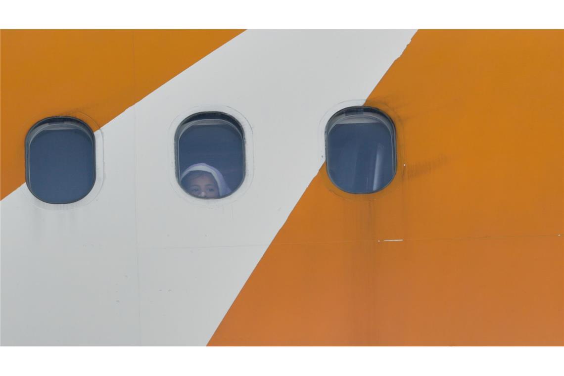 Ein Kind blickt aus einem von Venezuela betriebenen Flugzeug, das mit abgeschobenen Migranten aus den USA auf dem Flughafen Simon Bolivar International in Maiquetia ankommt.