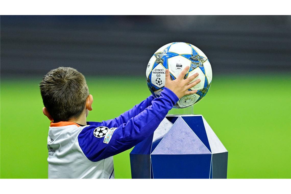 Ein Kind nimmt beim Einlauf der Mannschaften den Spielball in die Hände.