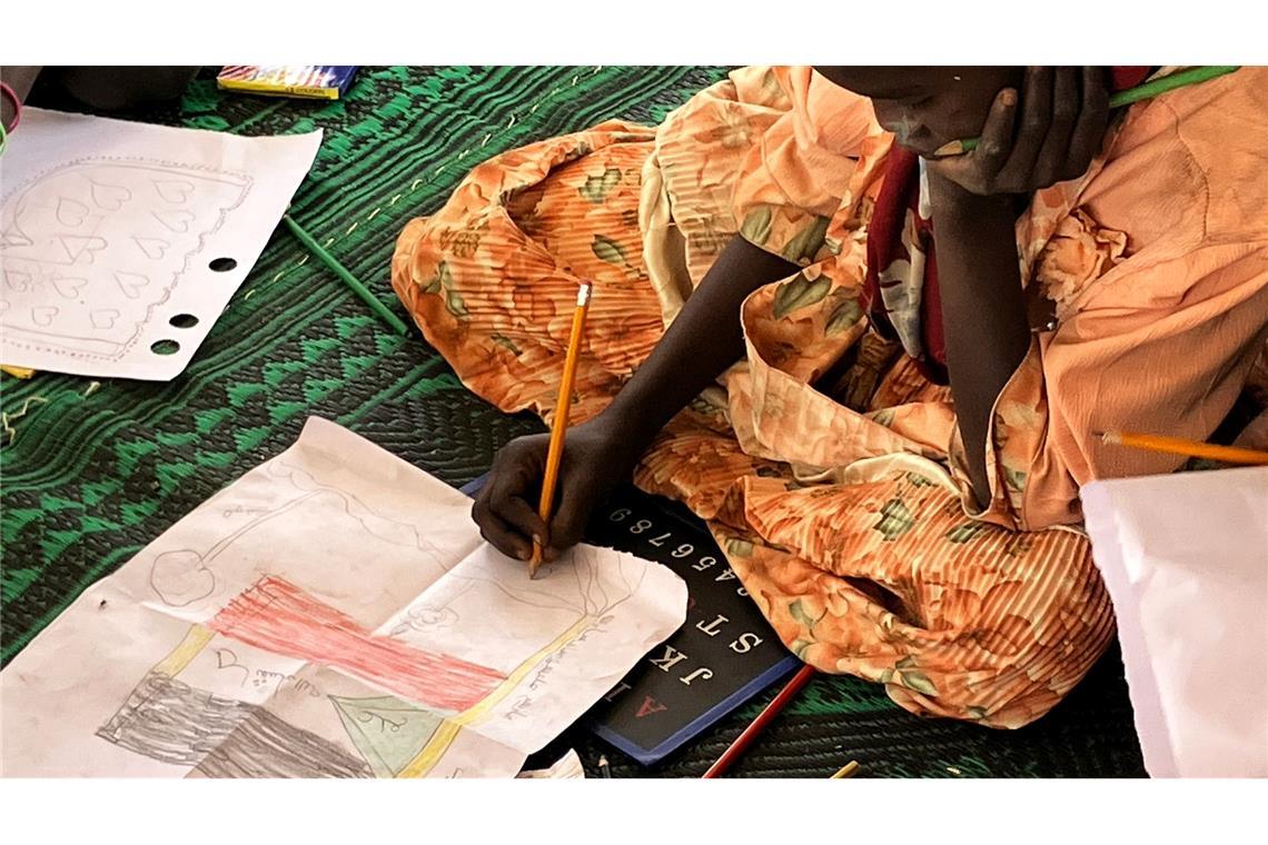 Ein kleines Mädchen malt die sudanesische Flagge.