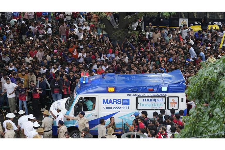 Ein Krankenwagen bahnt sich den Weg durch eine Menschenmenge am M. Chinnaswamy-Stadion in der indischen Stadt Bengaluru.