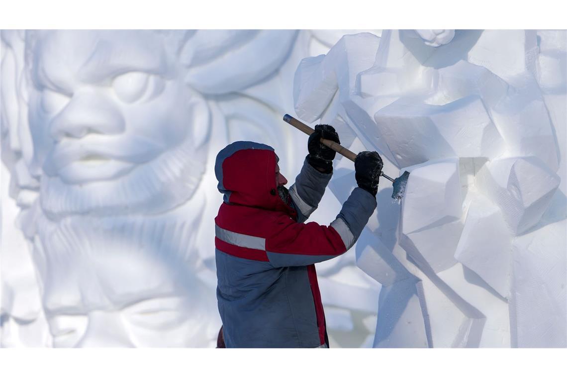 Bilder des Tages Ein Künstler arbeitet im chinesischen Harbin während eines Festivals, auf dem Schneeskulpturen gezeigt werden, an einem Kunstwerk aus Schnee und Eis.