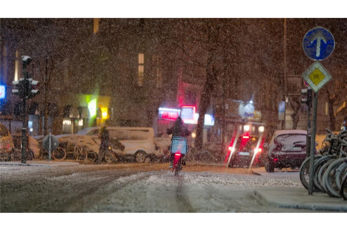 Bilder des Tages Ein Lieferdienstfahrer fährt auf einer verschneiten Straße in der Innenstadt von Köln.