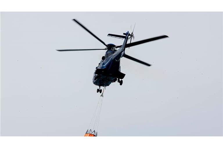 Ein Löschhubschrauber der Bundespolizei fliegt über dem Zeithainer Tagebau und nimmt Wasser auf, um den Waldbrand Gohrischheide zu bekämpfen.