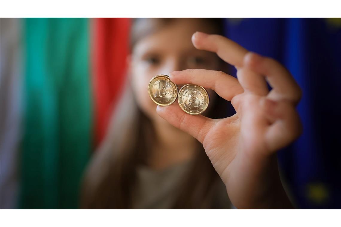 Ein Mädchen zeigt neue Euro-Münzen mit bulgarischen Symbolen.