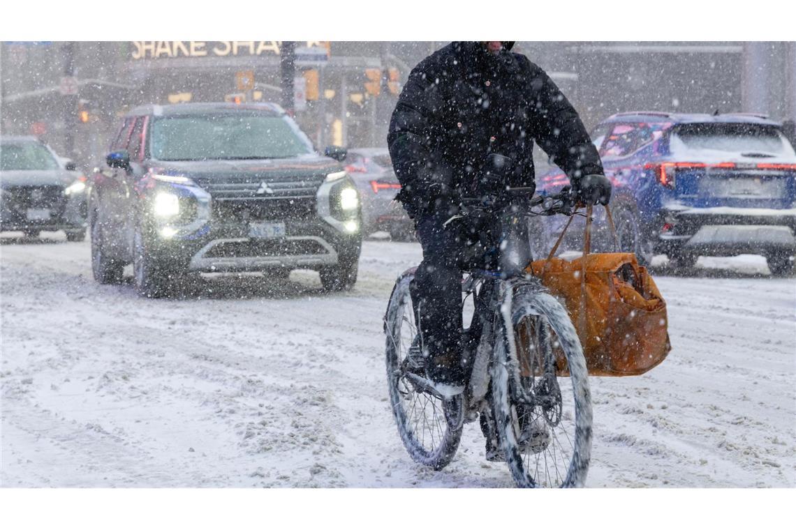Ein Mann fährt an einem verschneiten Tag in Toronto auf einem E-Bike.