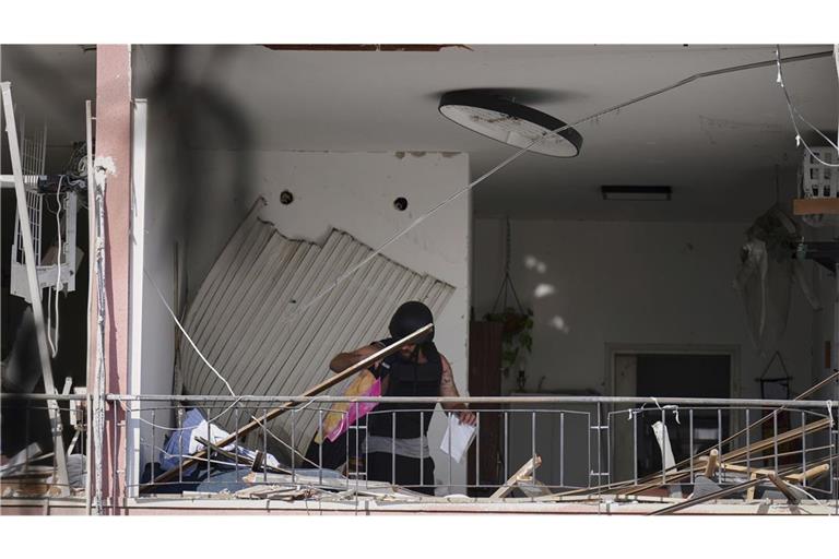Ein Mann holt in der israelischen Hafenstadt Habseligkeiten aus einer Wohnung, die nach dem Einschlag einer iranischen Rakete beschädigt wurde.