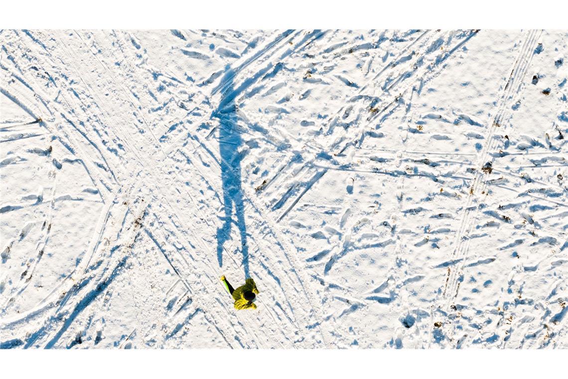 Ein Mann joggt am Kronsberg und wirft einen langen Schatten (Luftaufnahme mit Drohne).
