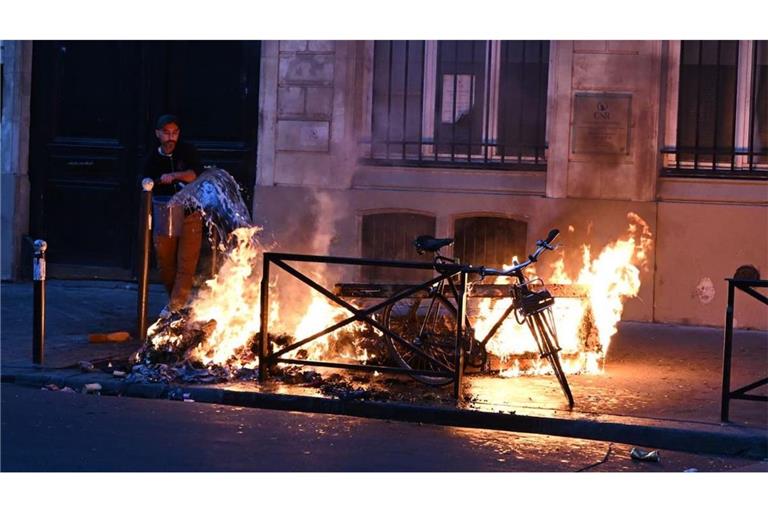 Ein Mann versucht in Paris, während der Zusammenstöße zwischen Demonstranten und Polizeibeamten ein Feuer zu löschen. 