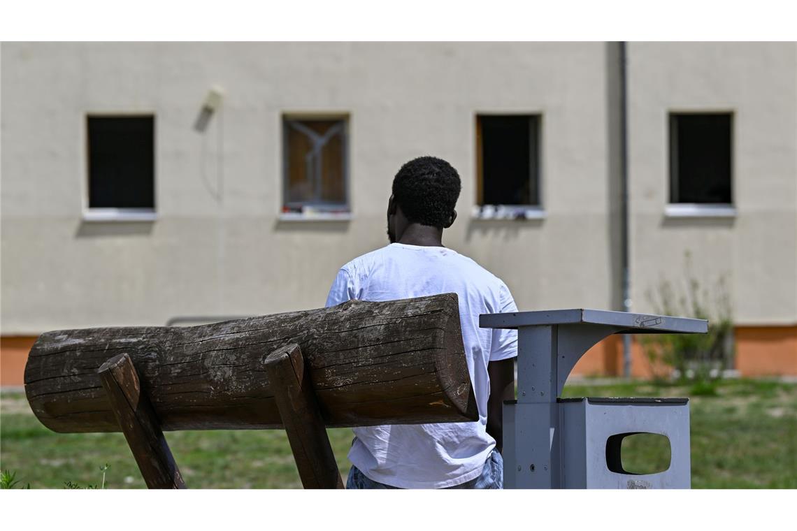 Gerichte heben nur noch relativ wenige Asylbescheide auf Ein Migrant sitzt auf einer Bank auf dem Gelände der Zentralen Erstaufnahmeeinrichtung für Asylbewerber des Landes Brandenburg in Eisenhüttenstadt. (Archivfoto)