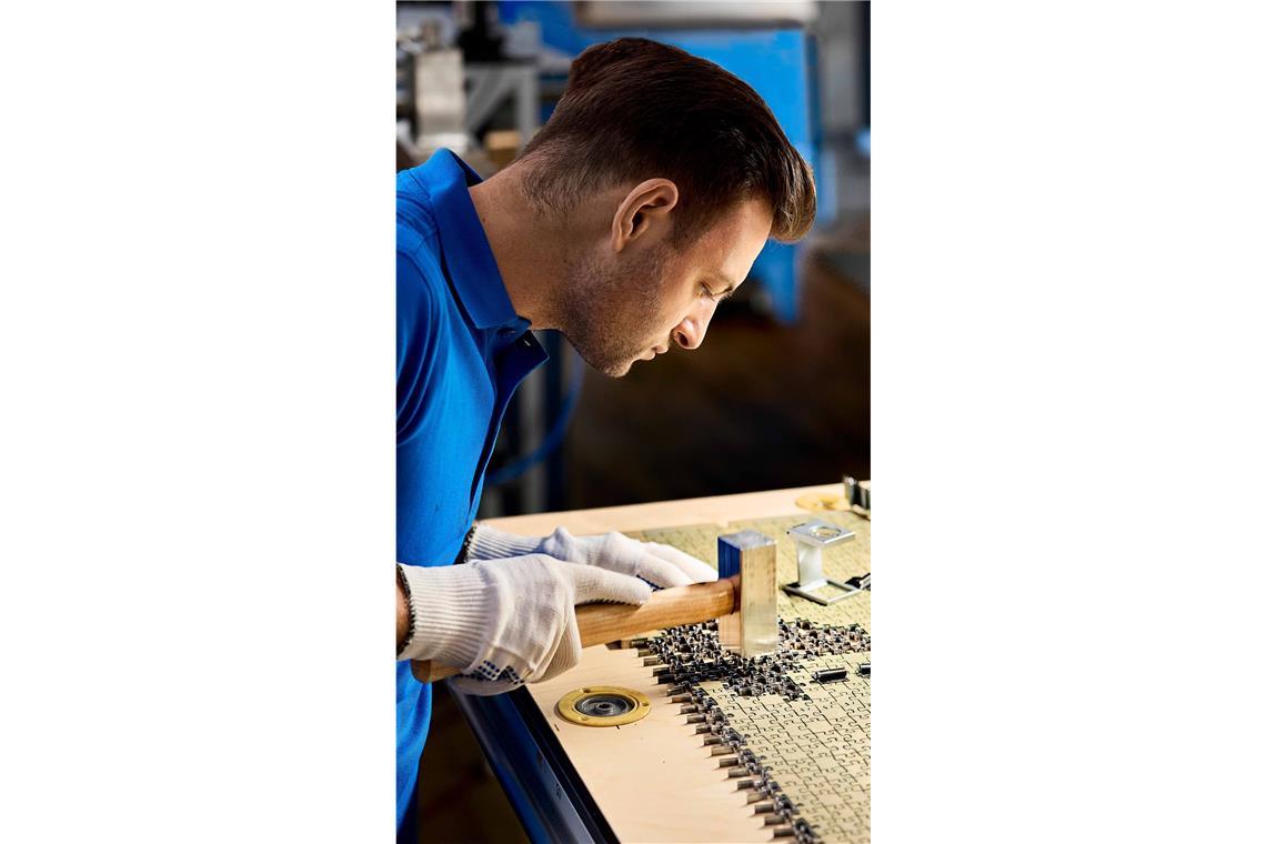 Nach dem Puzzleboom kommen die Sammelkarten-Fans Ein Mitarbeiter fertigt ein Stanzwerkzeug für die Produktion.