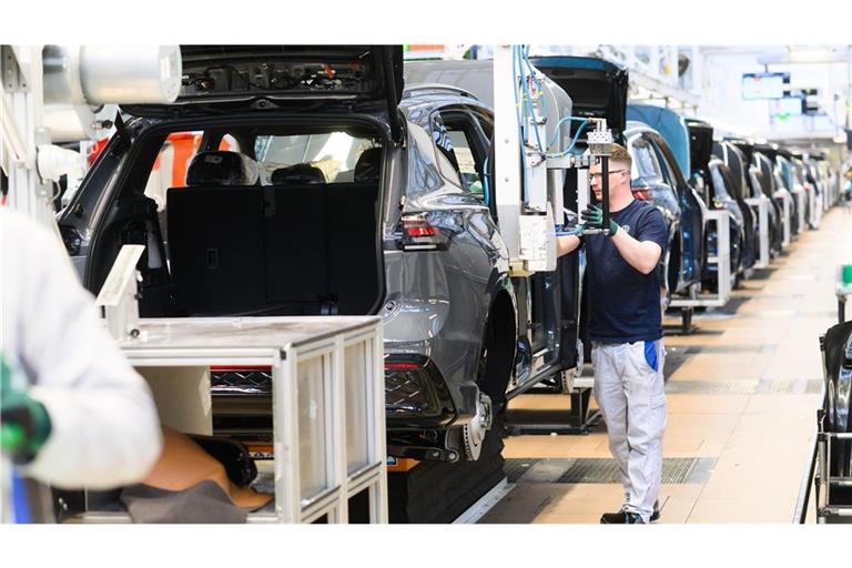 Ein Mitarbeiter montiert im VW Stammwerk Sitze in einen Neuwagen Volkswagen Tayron. Bei VW müssen wegen gestiegener Nachfragen Sonderschichten eingelegt werden (Archivfoto).