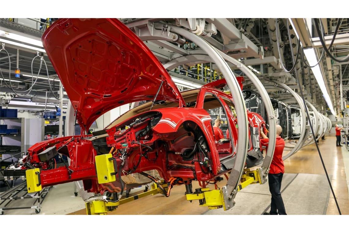 Ein Mitarbeiter montiert Kabelbäume in einen Panamera Hybrid im Leipziger Porsche-Werk.
