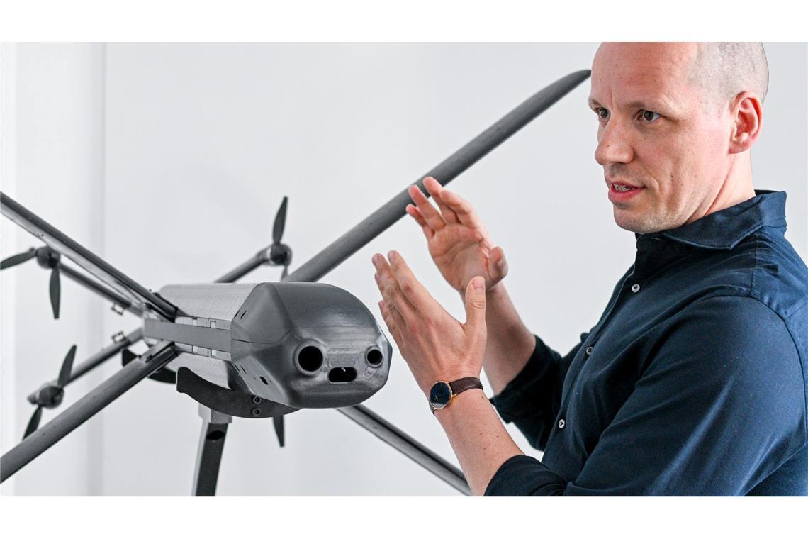 Ein Modell der HX-2-Drohne von Helsing, daneben der Mitgründer und Co-Firmenchef Gundbert Scherf.