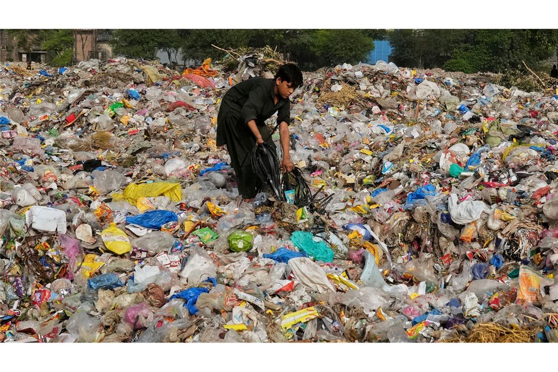 Bilder des Tages Ein Müllsammler sammelt wiederverwertbare Gegenstände, darunter Plastik, auf einer Mülldeponie in Lahore, Pakistan.