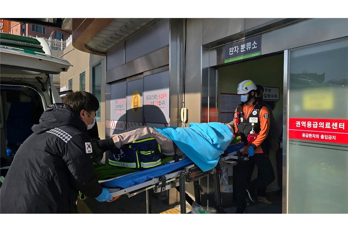 Flugzeug in Südkorea zerschellt - 179 Tote Ein nach einem Flugzeugabsturz gerettetes Opfer wird in ein Krankenhaus transportiert.