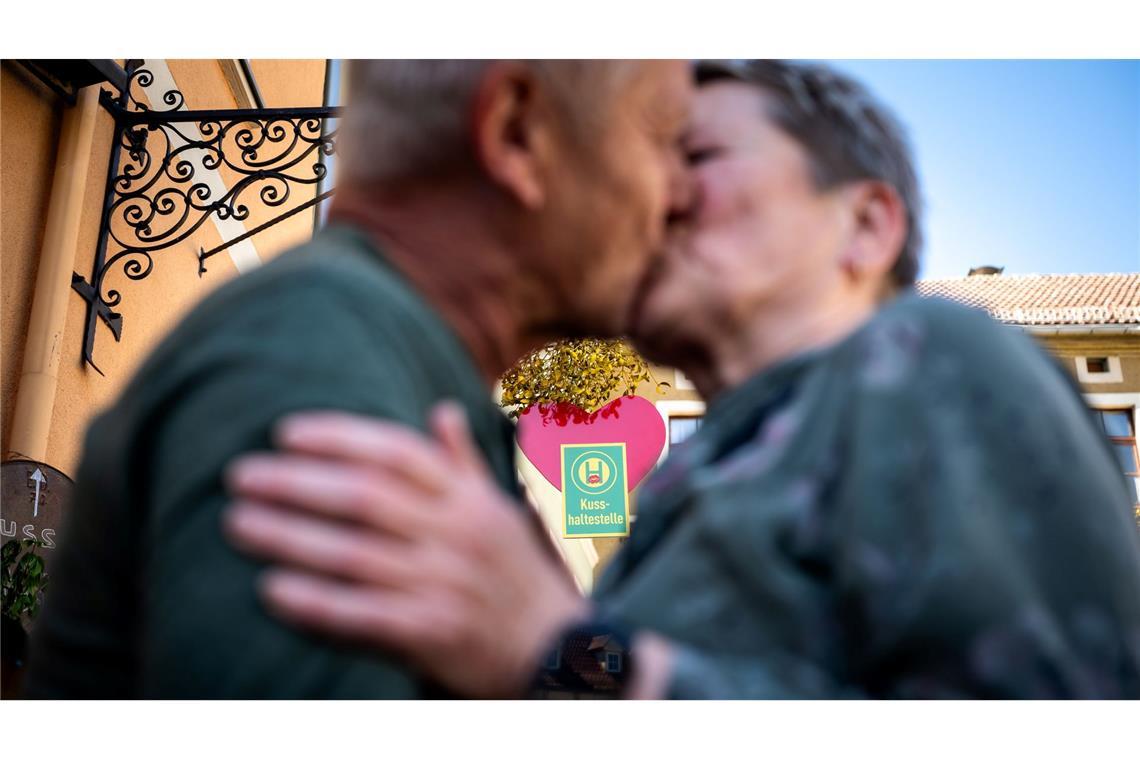 Ein Paar küsst sich an der Eisenberger "Kusshaltestelle".